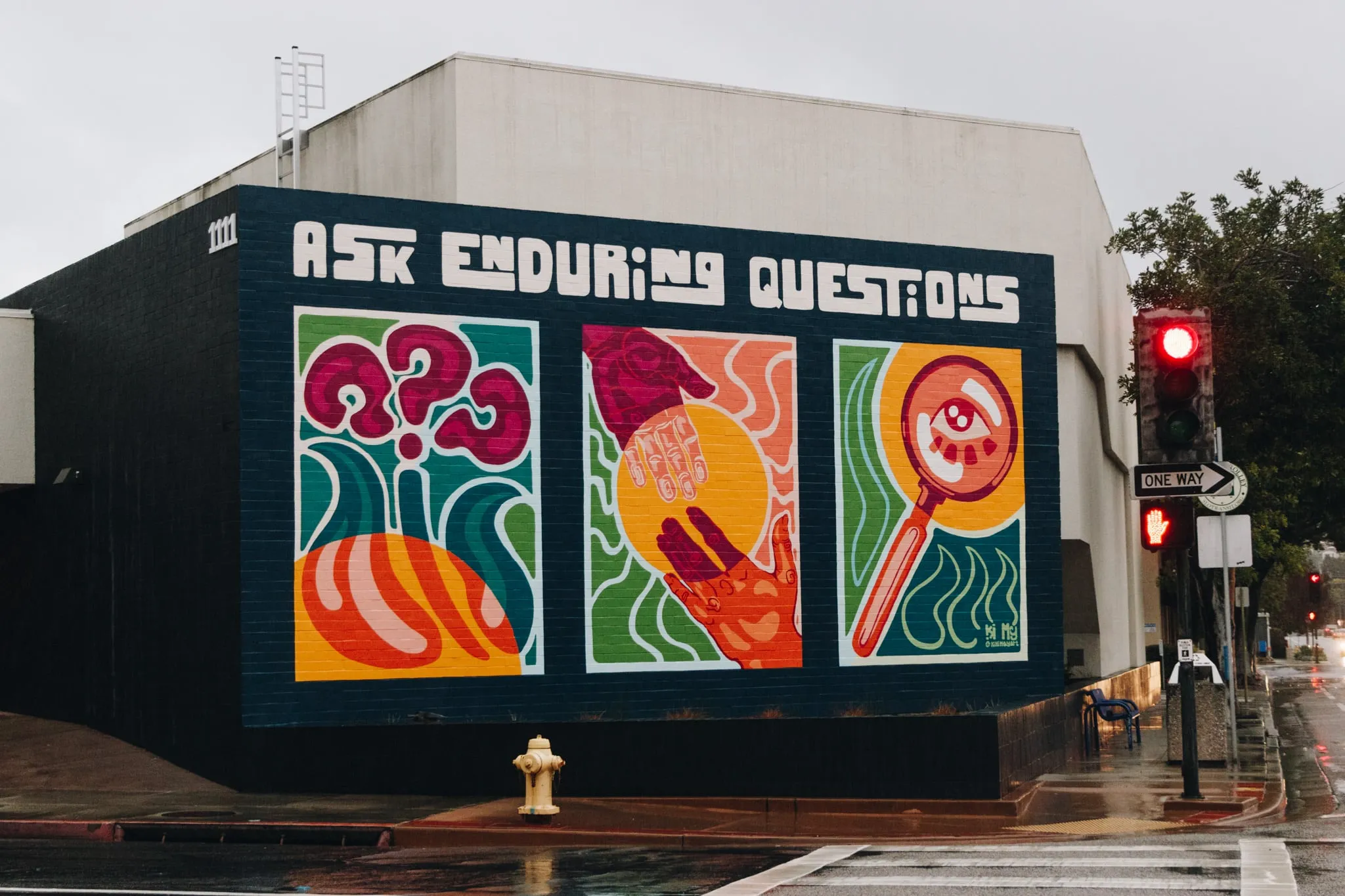 A mural reading “Ask Enduring Questions”.